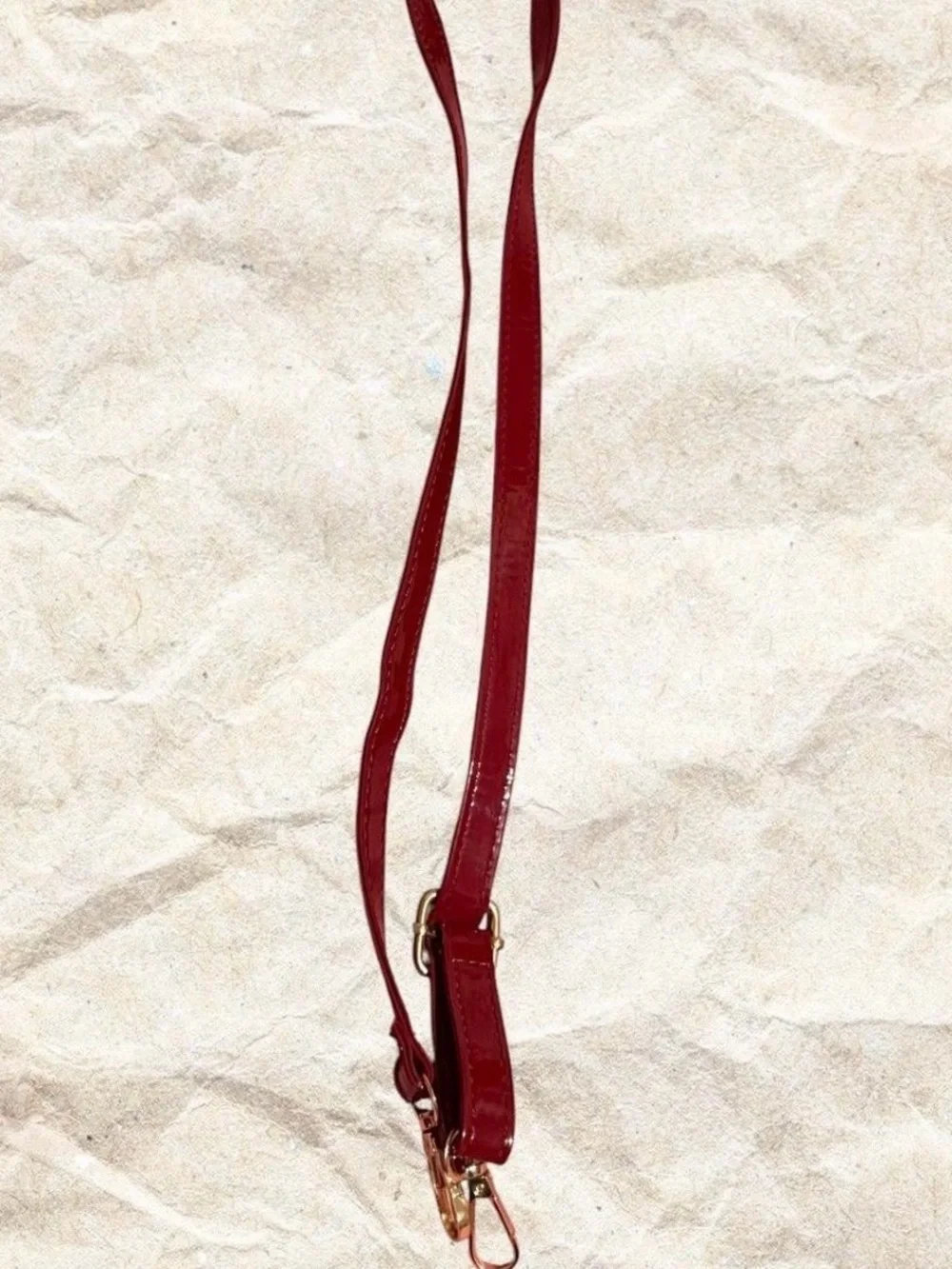 Red crocodile textured bow bag with gold hardware with removable strap